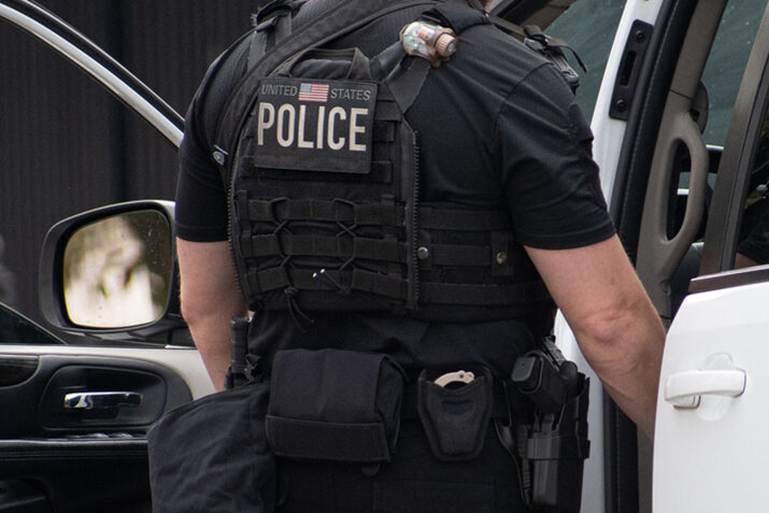 A photo of an officer is featured on a website. The officer wears a vest labeled "UNITED STATES POLICE".